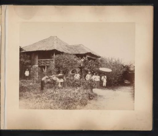 European man in front of his house with servants