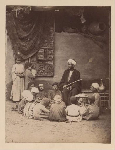 Portrait of a teacher with children around him, Egypt