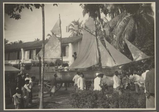 Men with a pageant wagon of a sailing ship at the palace of the Sultan of Langkat