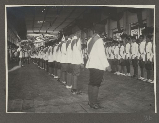 Row of boys in uniform with sashes in the reception hall of the palace of the Sultan of Langkat