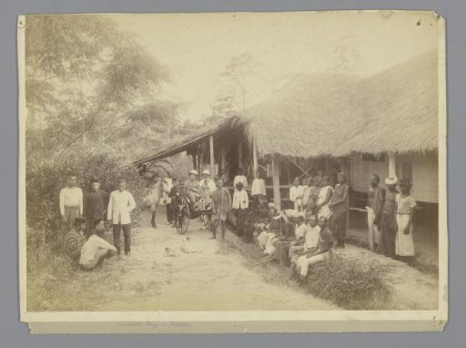 Contract workers and overseers in front of workers' dwellings