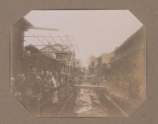 People on a Road Along a Polluted Canal in a Village in China