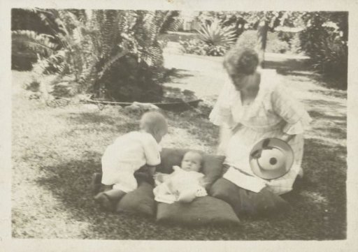 Mother with two small children in the grass