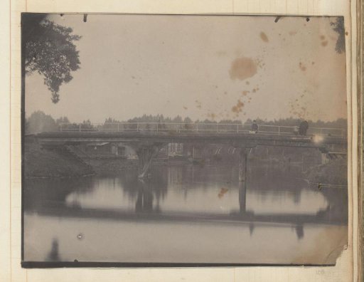 Bridge over a river with a man, woman, child and dog