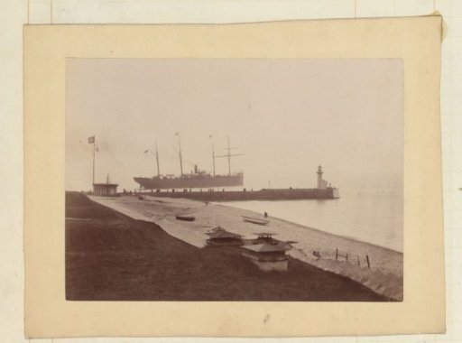 Ship departing from a pier with onlookers