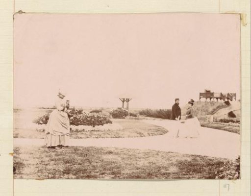 Man, two women and a young cat on a garden path at a lookout post