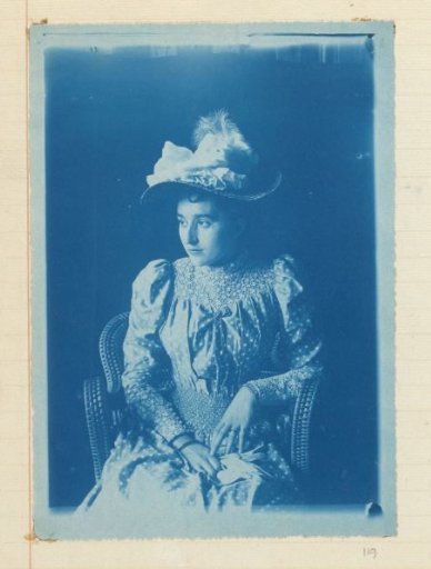 Portrait of a seated woman with hat and polka-dot dress