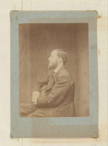 Portrait of a seated man with a beard, in profile to the left