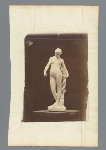 Statue of a female nude by a grapevine