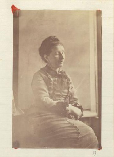 Portrait of a seated woman in a dress with ruffles and a hairband