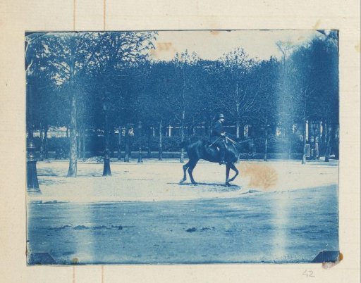 Man with hat on horseback in a park