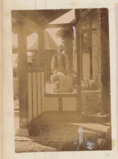 Woman stroking a dog at a house in a garden