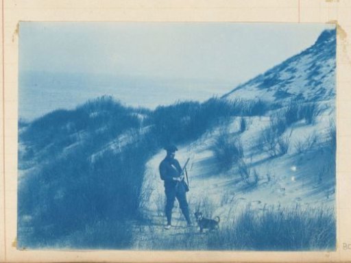Hunter in the dunes, standing with a dog