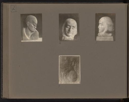Three sculptures of a face and a monument