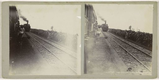 Women walking with baskets between two railway tracks