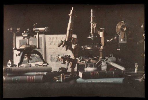 Still life with microscopes, books, and an open edition of Isaac Newton's Optics