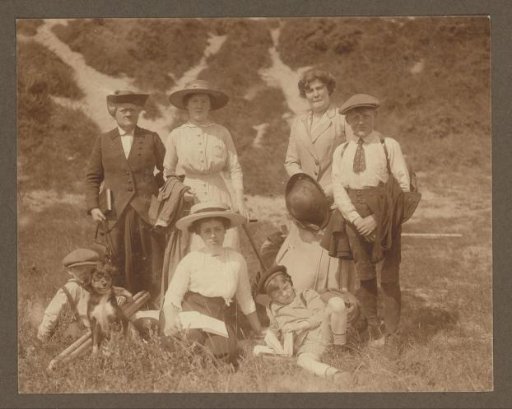 Group portrait of seven members of the Vermeulen family with a dog in the dunes