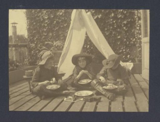 Three Boys in Costume Eating a Sandwich in a Homemade Tent on the Balcony