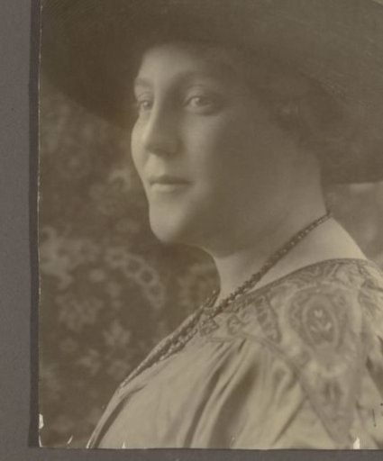Portrait of a Tine with a hat and a beaded necklace