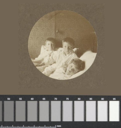 Group portrait of three Vermeulen children in bed