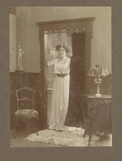 Portrait of a Vermeulen child in a dress in a doorway, with a statue in the corner