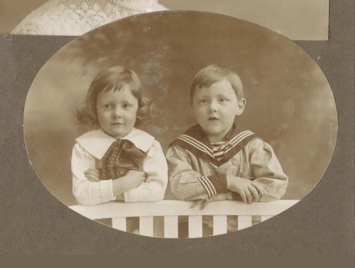 Portrait of a boy and a girl leaning on a fence