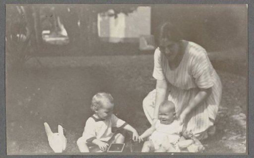 Tine Kleiterp-Vermeulen and her children Klaas and Tiny on a grassy field in Madje on Celebes