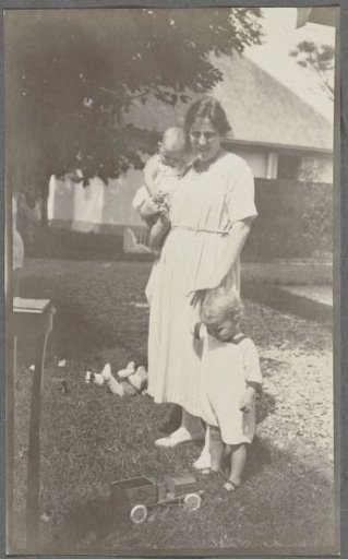 Tine Kleiterp-Vermeulen and her children Klaas and Tiny on a grassy field in Madje on Celebes