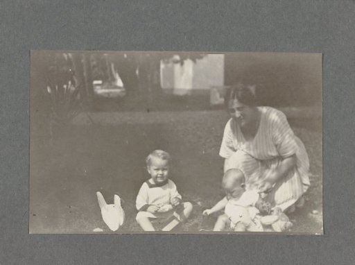 Tine Kleiterp-Vermeulen and her children Klaas and Tiny on a grassy field in Madje on Celebes