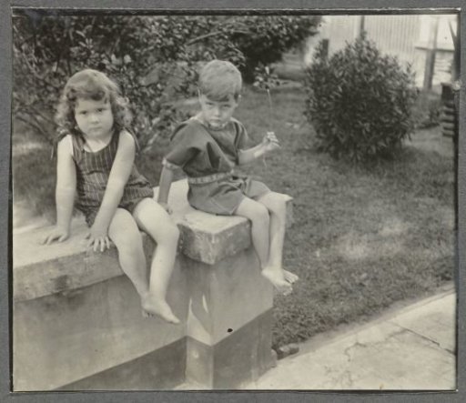Klaas and Tiny Kleiterp sitting on a garden wall in Singkawang