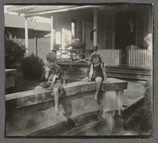 Klaas and Tiny Kleiterp sitting on a wall at a house in Singkawang