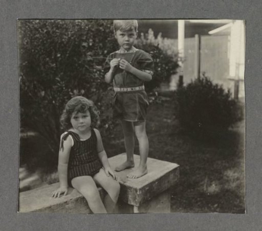 Klaas and Tiny Kleiterp sitting on a wall at a house in Singkawang
