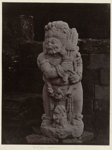 Statue of a temple guardian holding a percussion instrument at Candi Panataran.