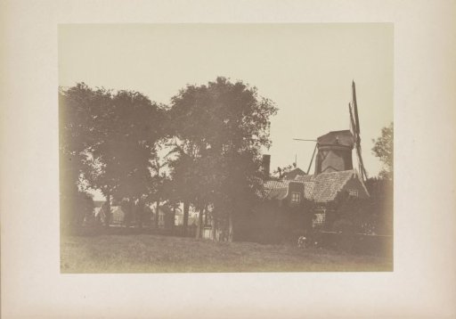 Landscape with the oil mill De Sint Willibrordus and small houses by the water in Zaandam