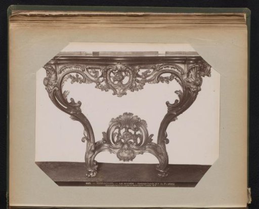 Wooden table with gilded base adorned with ornaments