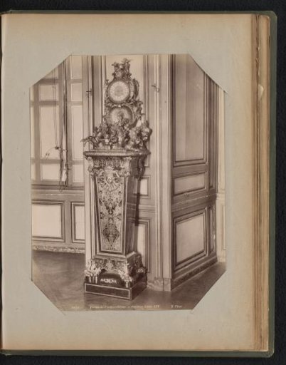 Pendulum clock on a wooden pedestal with gilded ornaments