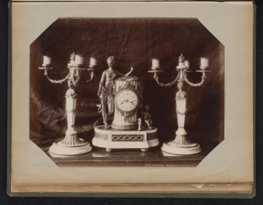 Clock case consisting of a clock with bronze figures and two bronze candlesticks