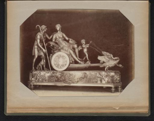 Gilded clock whose mechanism serves as the wheel of a carriage drawn by geese with an angel as the coachman