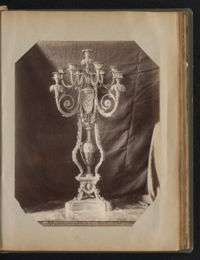 Decorated bronze eight-armed candelabrum resting on a foot