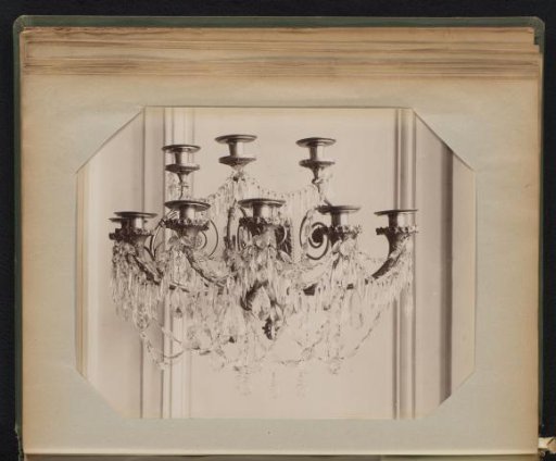 Bronze eight-armed wall sconce with floral decoration around the drip pans