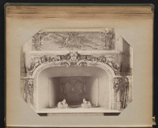 Marble mantelpiece decorated with lion heads and a human head in marble