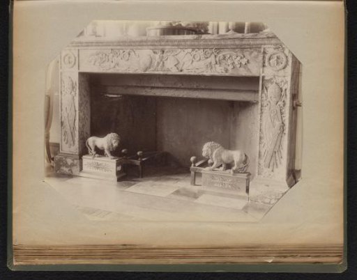 Marble mantelpiece decorated with family coats of arms and under two lion statues