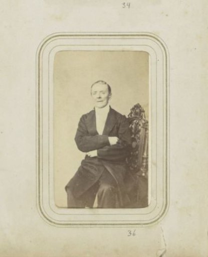 Portrait of a seated man with a long coat