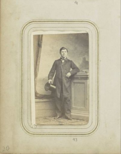 Portrait of a man with a tall hat in a long coat