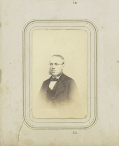 Portrait of a young man with glasses, short hair, and sideburns