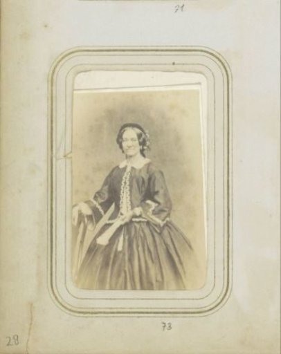 Portrait of a woman with a fan, wearing a wide skirt and a jacket