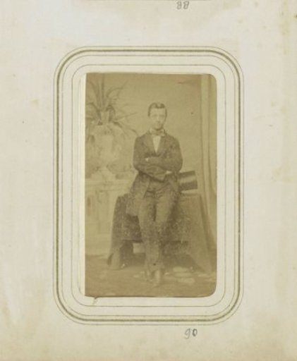 Portrait of a man in a coat with a tall hat in his hand