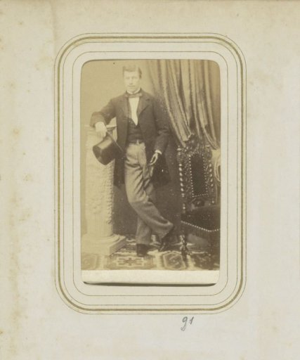Portrait of a man in a coat with a tall hat in his hand