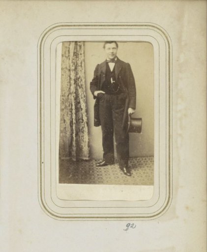 Portrait of a man in a coat with a tall hat and hand in his pocket