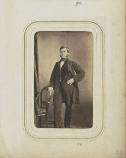 Portrait of a man with sideburns in a long coat